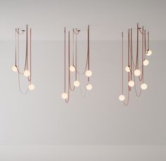 a group of lights hanging from the ceiling in a room with white walls and flooring