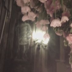 a bunch of flowers that are hanging from a light