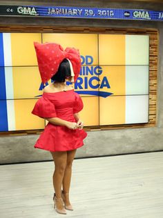 a woman in a red dress and big hat on the set of good morning america