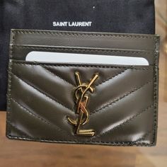 a saint laurent card holder is shown on a table