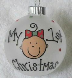 a glass ornament with a baby's face on it that says my 1st christmas