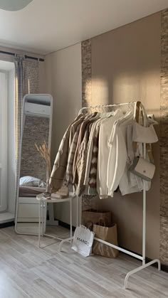 a room with clothes on racks and a mirror