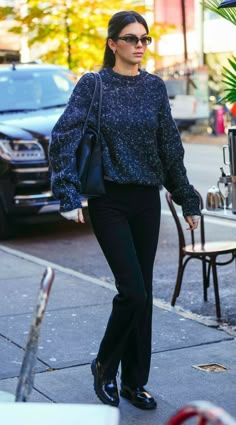 a woman walking down the street in black pants