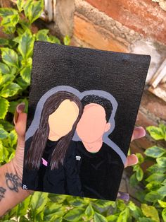 someone holding up a paper cutout of two people