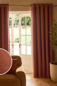 a living room with red curtains and a brown couch in front of a window that has a potted plant next to it