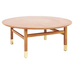 an oval wooden table with gold legs on a white background, viewed from the front