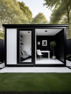 a small black and white house with sliding glass doors