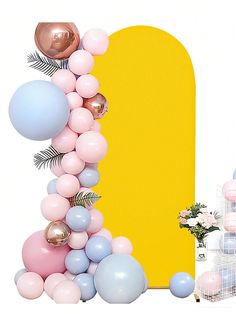 the balloon arch is decorated with pastel balloons and greenery, along with other decorations