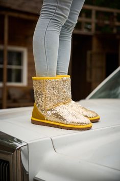 Spice up your shoe game with Smaibulun Ugg's Dallas Glam Sequin Shearling Boots! The perfect blend of style and comfort, these boots feature playful yellow glam sequins and cozy shearling lining. Who says ugg footwear has to be boring? (No one, that's who!) 1'' heel 7.6'' shaft 15.8'' circumference Pull-on Suede upper & Man-made sequins Faux fur lining EVA sole Trendy Yellow Winter Boots, Gold Boots With Round Toe For Winter, Reindeer Headband, Shearling Boots, Eva Sole, Daily Dress, Dress Jewelry, Shoe Game, Ugg Shoes