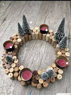 a wreath made out of wine corks with candles and pine cones on it, sitting on a wooden table