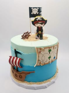 a birthday cake with a pirate on top and a flag sticking out of the top