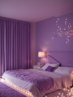 a bedroom with purple walls and lights on the bed, along with a chandelier