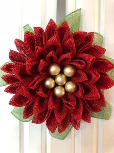 a red and green wreath with pearls on it