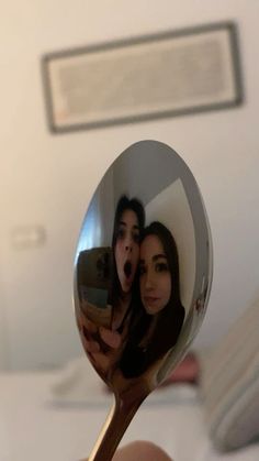 a person taking a selfie with a mirror on their spoon in front of them