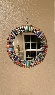 there is a mirror made out of books on the wall and a window in the background