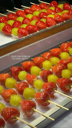 some strawberries and lemons are on sticks in front of the other trays