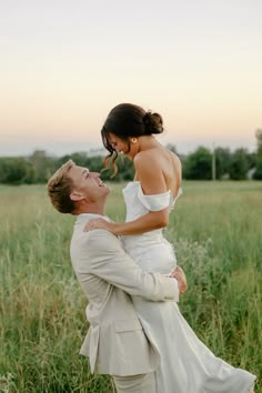 a woman in a white dress is holding a man