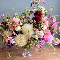 a vase filled with lots of different colored flowers