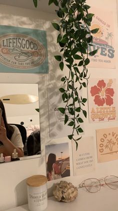 a woman taking a selfie in front of a mirror with pictures on the wall