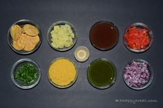 six bowls filled with different types of food on top of a black countertop next to sauces and condiments