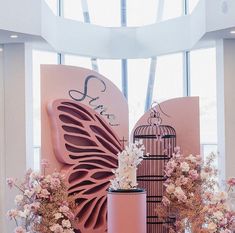 a pink display with flowers and a birdcage