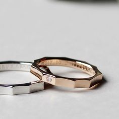 two wedding rings sitting on top of a table