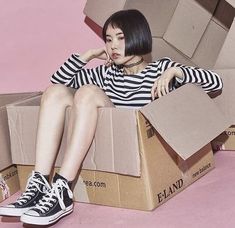 a woman sitting in a box with her legs crossed