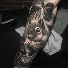 a man's arm with a squirrel and leaves on it