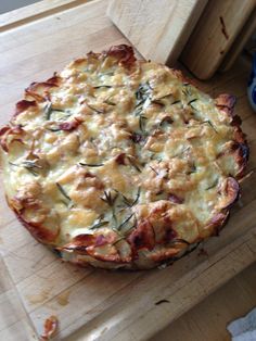 a pizza sitting on top of a wooden cutting board