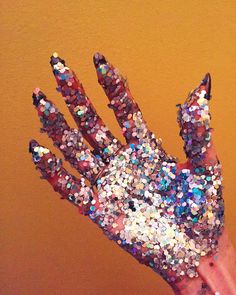 a person's hand covered in multicolored confetti