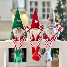 three christmas gnomes sitting on top of a table