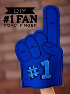 a hand holding up a foam finger sign with the number 1 on it's fingers