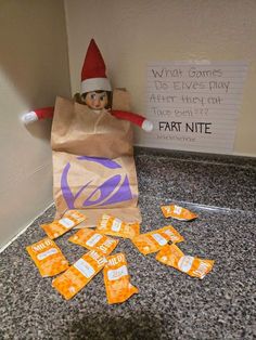 an elf is sitting on the floor next to some candy bars