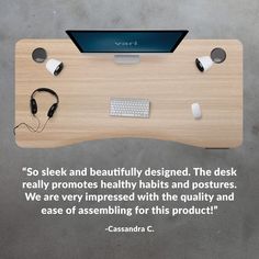 a wooden desk topped with a computer and headphones