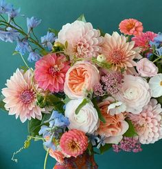 a vase filled with lots of pink and blue flowers