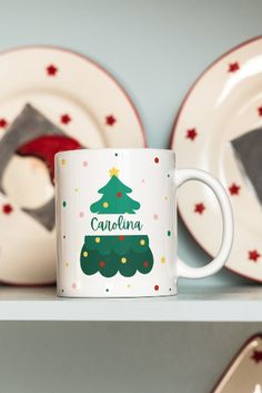 a white coffee mug sitting on top of a shelf next to plates and cups with red stars