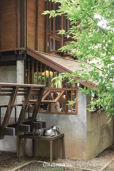 there is a pair of shoes sitting on the bench under the stairs in front of this house