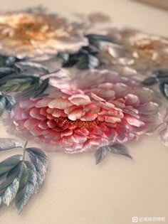 a close up of a flower on a table with leaves and flowers painted on it