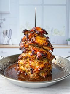 some food is stacked on top of each other in a metal pan with tongs