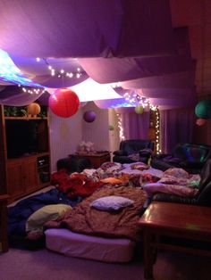 a living room filled with lots of furniture and balloons hanging from the ceiling above it