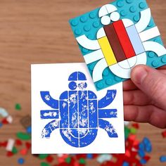 a hand holding up a card with a lego turtle on it