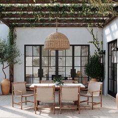 an outdoor dining area with wicker furniture and potted plants