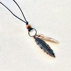 The bohemian feather necklace for men is an authentic piece of Native American jewelry, featuring a unique leather design. This spiritual jewelry also makes an eco-friendly gift for women, with intricate native beading that highlights its cultural significance. 🪶 𝗠𝗔𝗧𝗘𝗥𝗜𝗔𝗟𝗦 + 𝗗𝗜𝗠𝗘𝗡𝗦𝗜𝗢𝗡𝗦 ❯  Leather, wood, shell, metal ❯  Pendant is 3 inches long 🪶 𝗦𝗧𝗢𝗡𝗘 + 𝗘𝗟𝗘𝗠𝗘𝗡𝗧 𝗘𝗡𝗘𝗥𝗚𝗬 ❯  ABALONE is known for its powers of warding off negativity ❯  WOOD symbolizes life, growth and strength ❯  COPPER enhances positive energy flow 🪶 𝗣𝗘𝗥𝗦𝗢𝗡𝗔𝗟𝗜𝗭𝗔𝗧𝗜𝗢𝗡 + 𝗚𝗜𝗙𝗧 𝗦𝗘𝗧 𝗦𝗨𝗚𝗚𝗘𝗦𝗧𝗜𝗢𝗡𝗦 ❯  Abalone Bracelet (photo 6) -- lorenlavinedesigns.etsy.com/listing/641362537 ❯  Custom Engraved Charm (photo 8 + 9) -- lorenlavinedesigns.etsy.com/listing/1773821992 ? Adjustable Bohemian Necklaces With Feathers, Bohemian Brown Feather Jewelry, Black Bohemian Necklace For Everyday Use, Black Bohemian Necklace For Everyday, Bohemian Brown Necklace For Everyday Use, Adjustable Feather Necklace As Gift, Abalone Bracelet, Bohemian Style Men, Native Beading