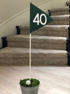 a golf ball sitting on top of a green flag next to some stairs and a potted plant