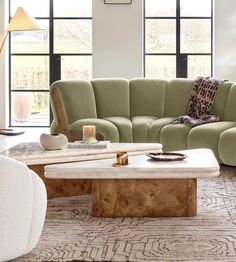 a living room with two couches and a coffee table in front of large windows