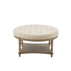 a round wooden table with a white cushion on top and legs in the shape of a footstool