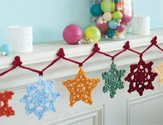 crocheted stars are hanging from a mantle