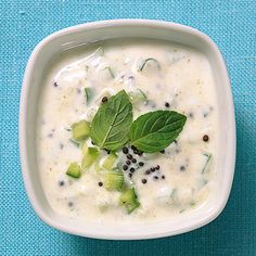 a white bowl filled with soup on top of a blue table