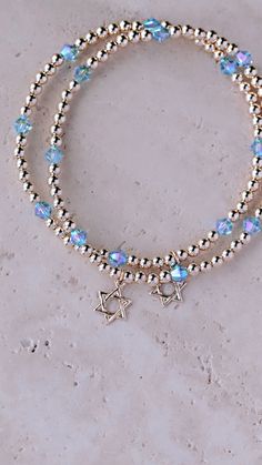 Beautiful 3mm 14kt gold filled ball beads accented by blue Swarovski crystals and gold filled Star of David charm. This listing is for 1 bracelet. This gold bracelet will not fade or tarnish. This item is made to order so please allow 8-10 business days for item to ship. Thank you for your business and happy Shopping!! Star Beaded Bracelet, Jewish Star, Gold Armband, Star Of David, 14kt Gold, Beaded Bracelet, Arm Band, Hanukkah, Swarovski Crystals