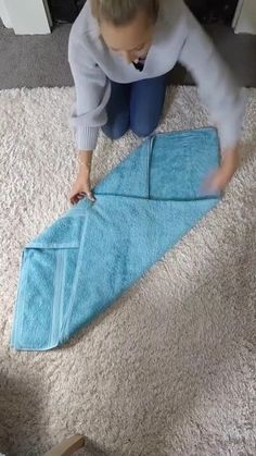 a woman kneeling on the floor with a blue towel